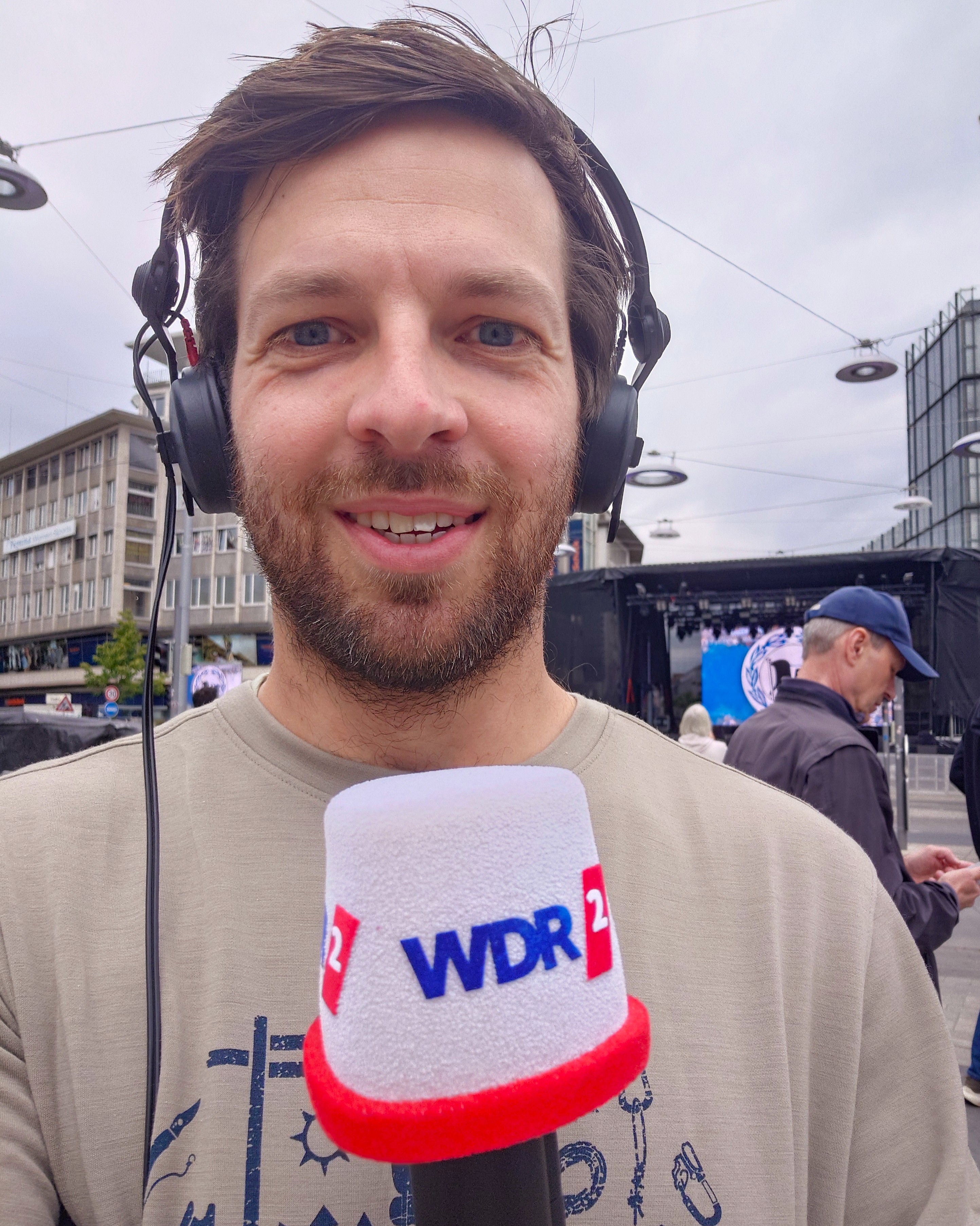 Tim Belke mit Kopfhörer und WDR2-Mikrofon
